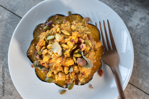 Φωτογραφία roasted acorn squash bowls filled with bread stuffing and herbs on white plate f