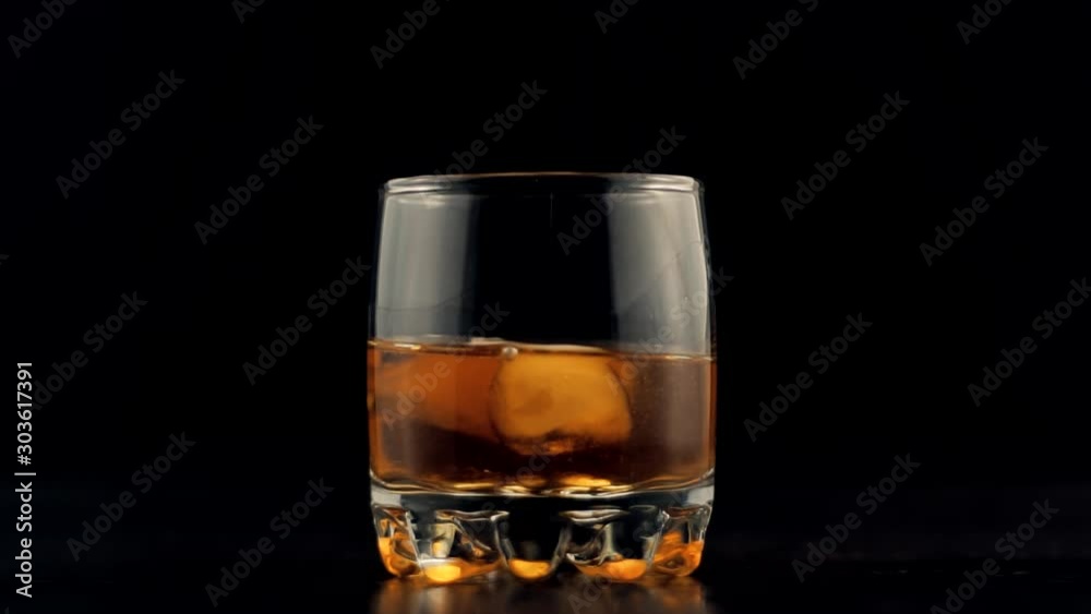 Whiskey Pouring In Glass.Cognac In Glass Floats In Slow Motion.Bourbon Or Rum Pouring In Slow Motion.Running Brandy In Glass From Bottle.Rum Flowing From Brown Bottle. Whiskey Pouring In Glass.Cognac In Glass Floats In Slow Motion.Bourbon Or Rum Pouring In Slow Motion.Running Brandy In Glass From Bottle.Rum Flowing From Brown Bottle.