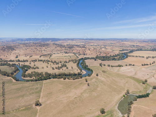 Panoramic high angle aerial drone view of rural New South Wales, Australia, near the town of Gundagai on a sunny day. Gentle hills, a country road and the Murrumbidgee River in the background. photo
