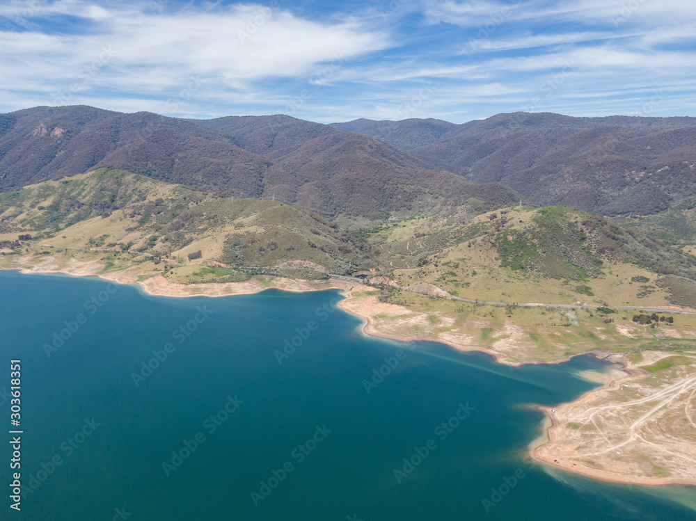 High angle aerial drone view of Blowering Reservoir (dam) near Tumut in the Snowy Mountains region of New South Wales, Australia. Notice the low water levels due to ongoing drought in Australia.