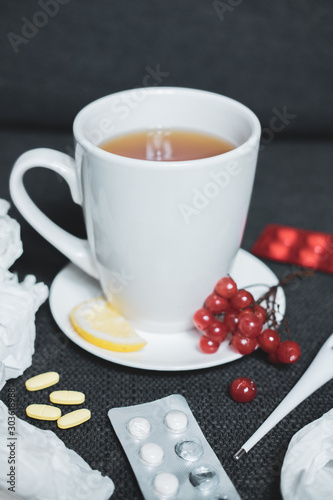 Сup of herbal tea and flu medicine on white background. The concept of a cold during the winter season