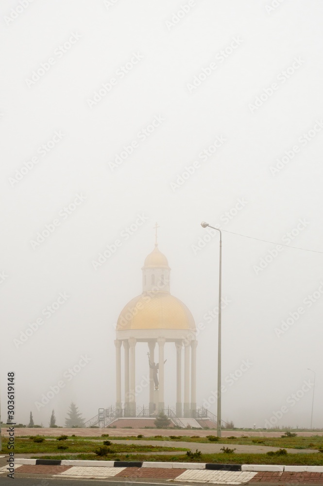 Heavy fog on freeway.  A round chapel in a strong mist
