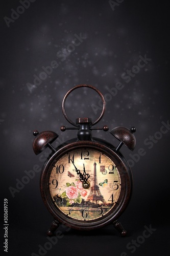 An old vintage clock with sparkles on a black background