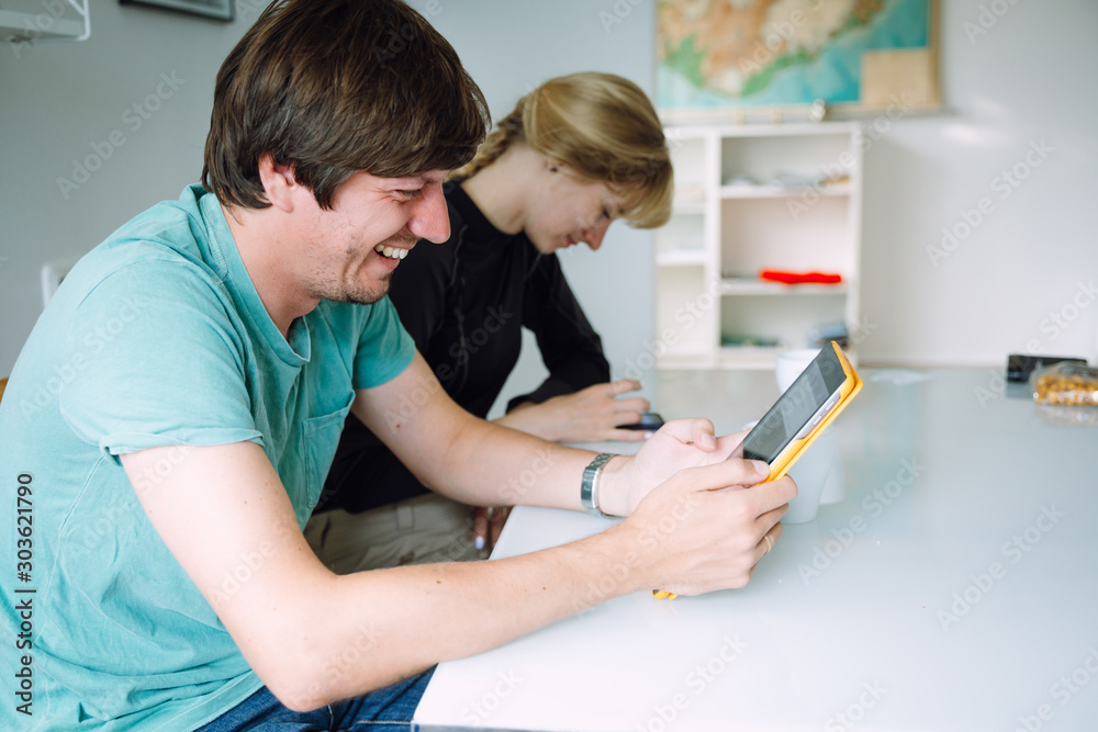 man looking into a digital tablet and a woman using a mobile phone man looking into a digital tablet and a woman using a mobile phone
