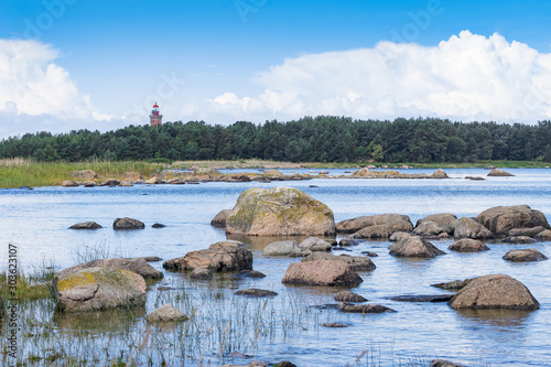 Boulders, forest, shore, evening light, sunset, clouds, blue sky and rainbow on the Baltic Sea. Mohni, small island in Estonia, Europe. photo