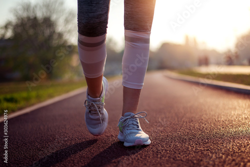 Close up, woman running outdoors.