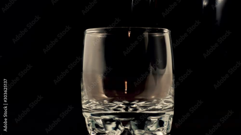 Whiskey Pouring In Glass.Cognac In Glass Floats In Slow Motion.Bourbon Or Rum Pouring In Slow Motion.Running Brandy In Glass From Bottle.Rum Flowing From Brown Bottle. Whiskey Pouring In Glass.Cognac In Glass Floats In Slow Motion.Bourbon Or Rum Pouring In Slow Motion.Running Brandy In Glass From Bottle.Rum Flowing From Brown Bottle.