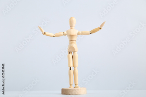 Wooden figure on grey background