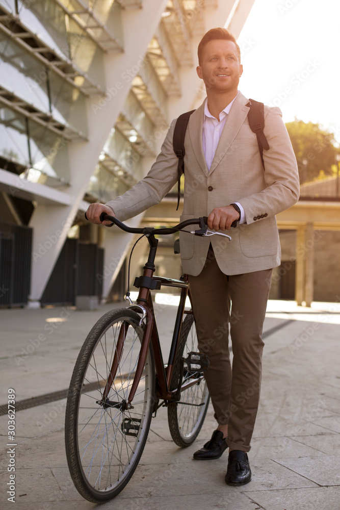 Optimistic businessman pushing his bicycle stock photo Optimistic businessman pushing his bicycle stock photo