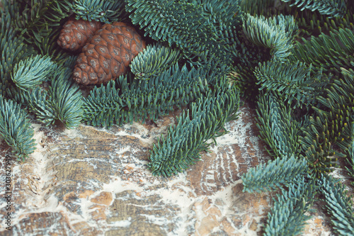 Frame of fir branches, cones on a wooden background. Christmas composition.