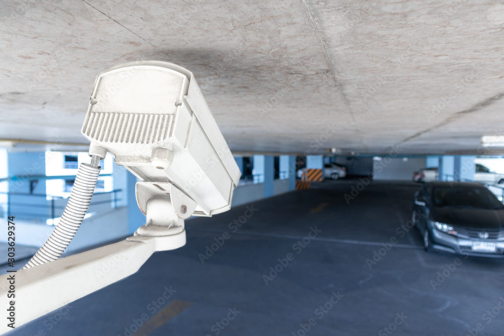 Security CCTV camera under ceiling operating in car park. Security and ...