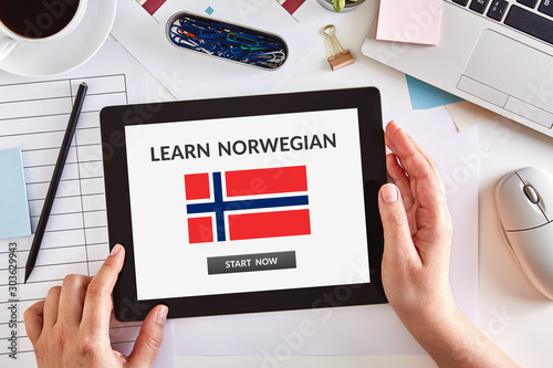 Hands using tablet with learn Norwegian concept on screen
