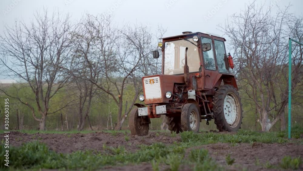 Tractor plowing the garden. Plowing the soil in the garden. Tractor plowing the garden. Plowing the soil in the garden.