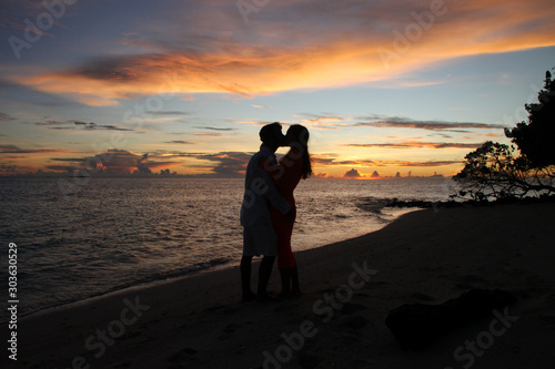 Silhouette of couple kissing during sunset on a tropical beach