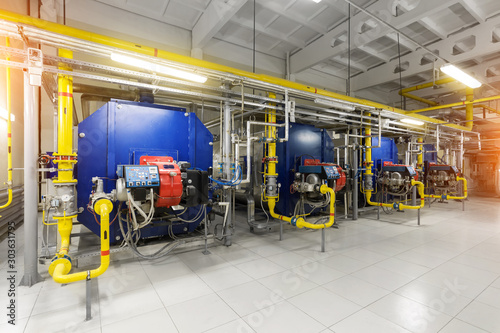 Modern industrial gas boiler room equiped for heating process. Heating gas boilers, pipelines, valves.