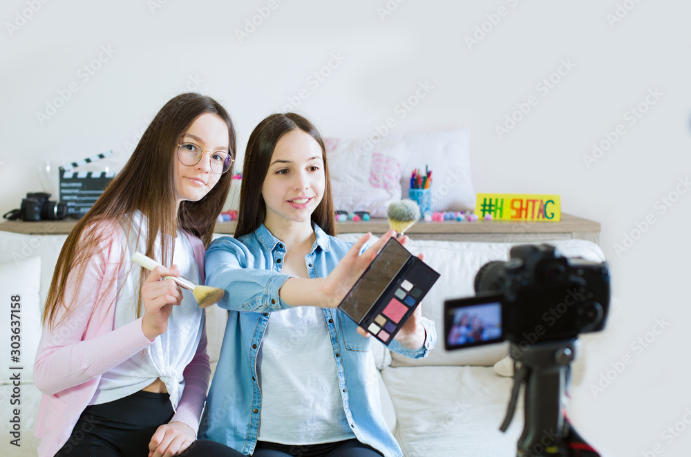 Two teen girls blogger presents beauty products and transmitting live video to social networks. Focus on the influencer of teenage blogger girls. Beauty blogger and vlog concept. Two teen girls blogger presents beauty products and transmitting live video to social networks. Focus on the influencer of teenage blogger girls. Beauty blogger and vlog concept.