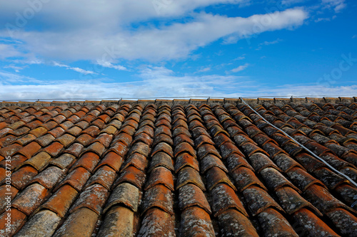 old clay tile roof against blue sky © chrupka