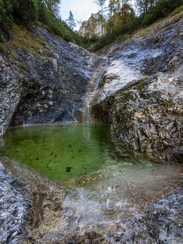 Φωτογραφία The waterfall and the pool of water in the in the rocks in the mountain stream b