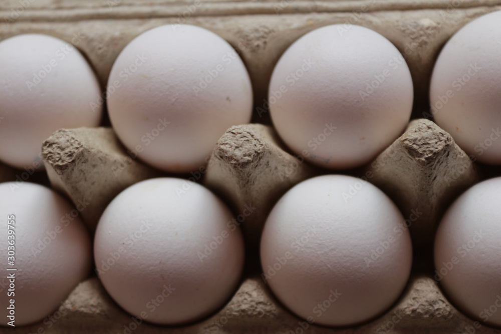 many light chicken eggs lie in a paper tray