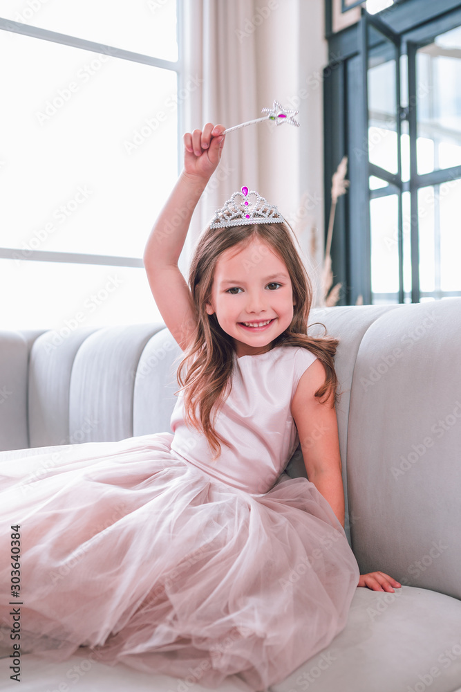 girl holding up magic stick sitting on the couch and smiling on the camera girl holding up magic stick sitting on the couch and smiling on the camera