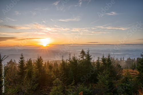 Gorgeous sunrise with fog in the mountains with trees in the foreground, Czech, Lysa Mountain