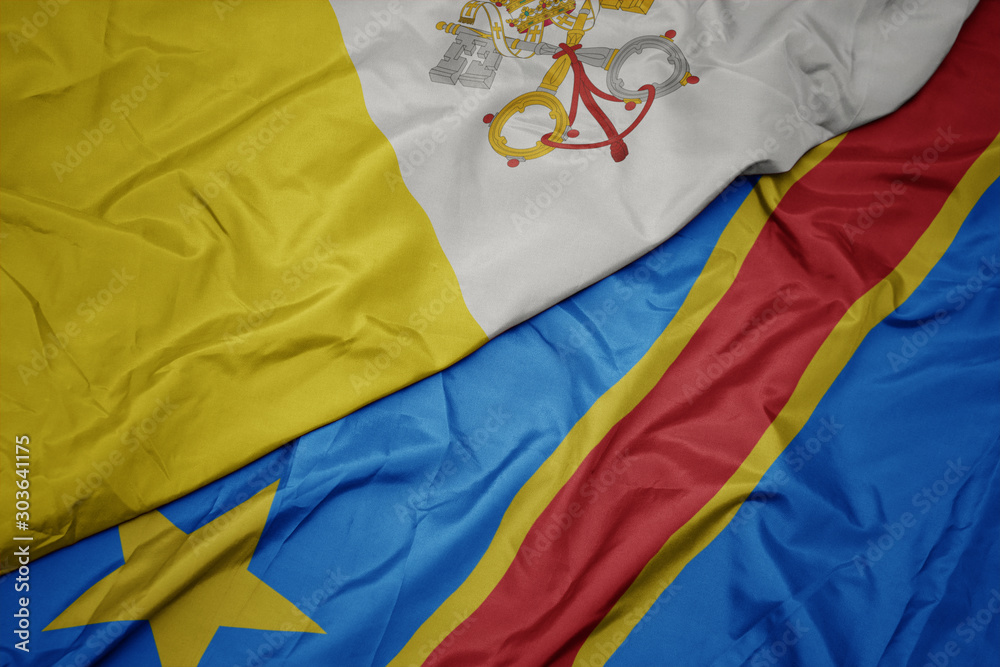waving colorful flag of democratic republic of the congo and national flag of vatican city.