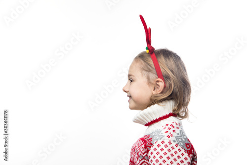 Funny kid with Christmas band. Cheerful smiling little girl .