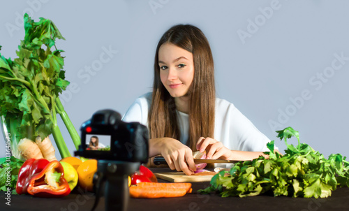 Teenage blogger talks to followers about the advantages of eating organic fruit and vegetables. Concept of communication to adolescents by a young influenzer of the benefits on well-being due to healt photo