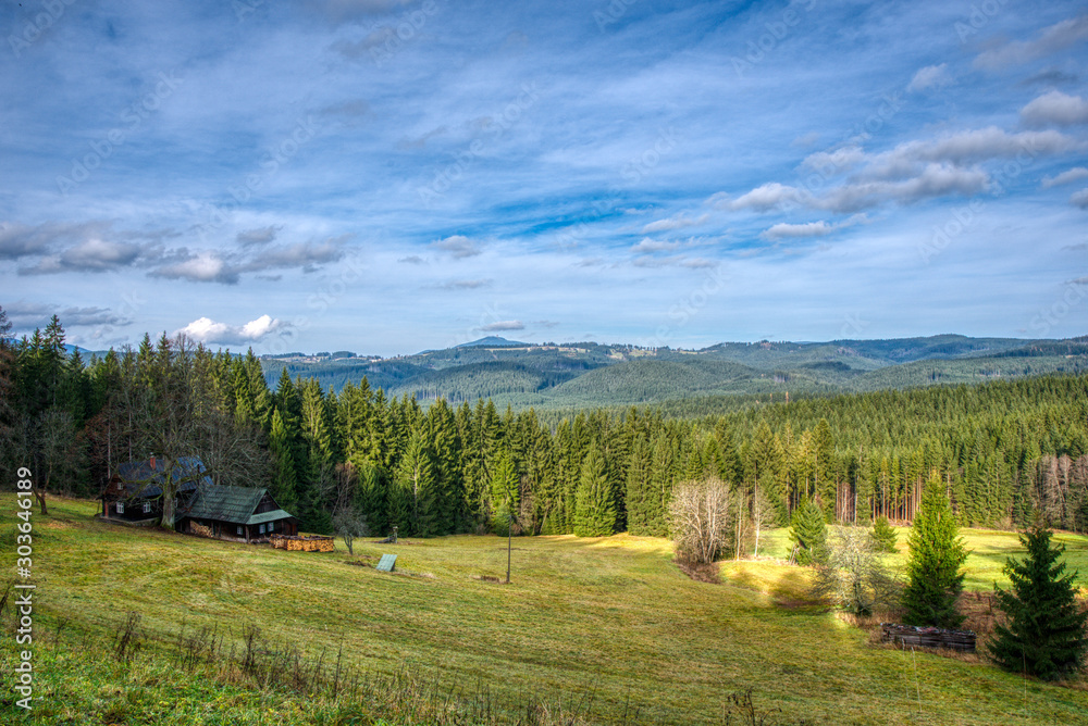 cottage in the mountains with meadow and beautiful forests in central europe