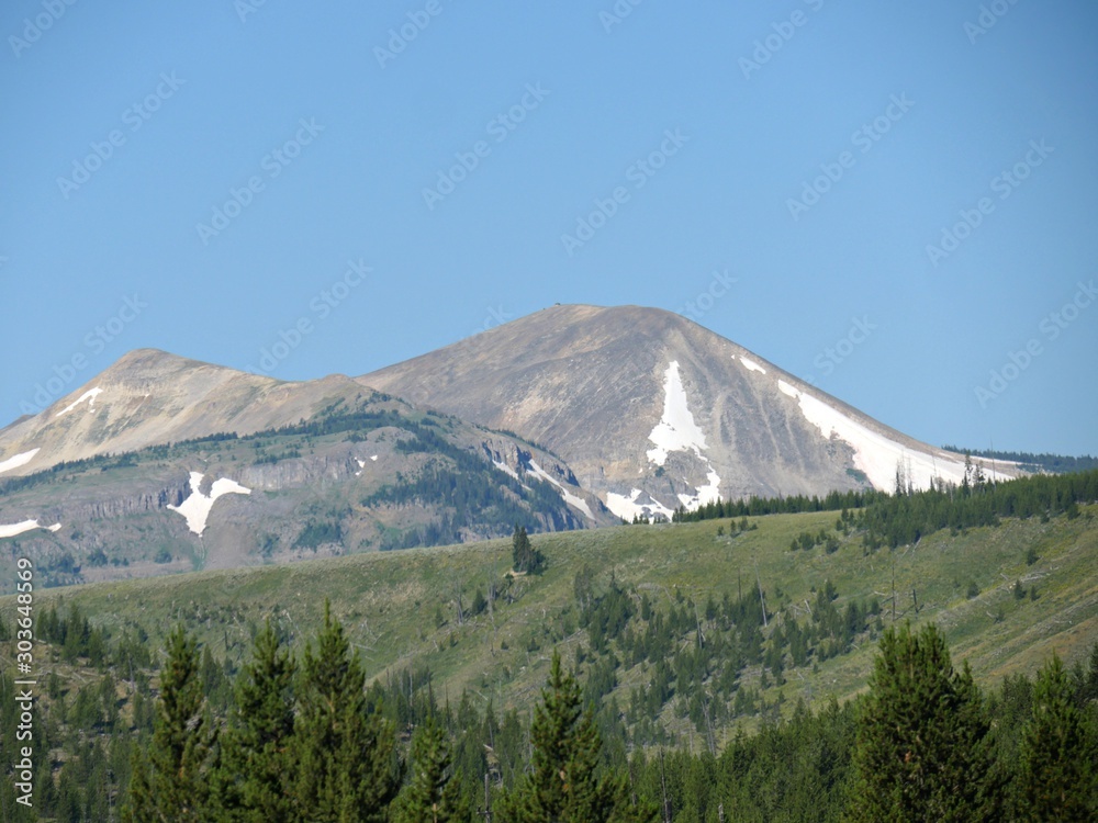 Upward shot of distant mountains partially covered with snow at Yellowstone National Park.