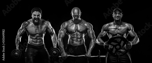 Three strong and fit men bodybuilders. Sporty muscular guys with barbell and dumbbells. Sport and fitness motivation. Individual sports recreation.