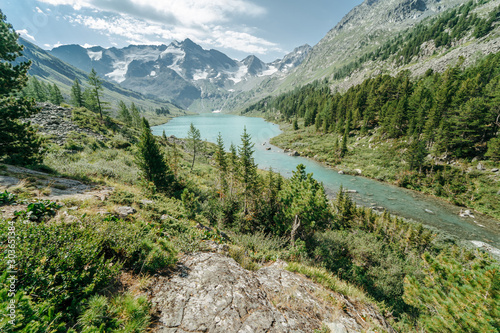 Wild russian nature. Beautiful landscape with emerald lake in the mountains. Lake with clear turquoise water. Traveling in the Altai Republic. Katun Nature Reserve.