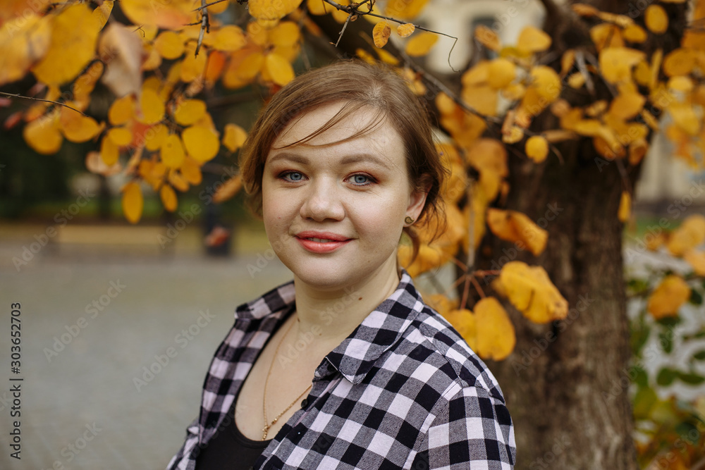 girl in a plaid shirt posing on a background of yellow wood girl in a plaid shirt posing on a background of yellow wood