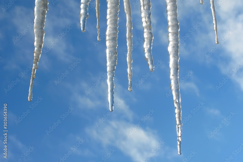 Icicles against the background of the blue sky Icicles against the background of the blue sky