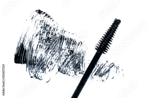 Black smear mascara and brush on white background. Trend concept. Isolated. Makeup. Cosmetic products for eyelashes. Photography. Top view. Beauty pattern