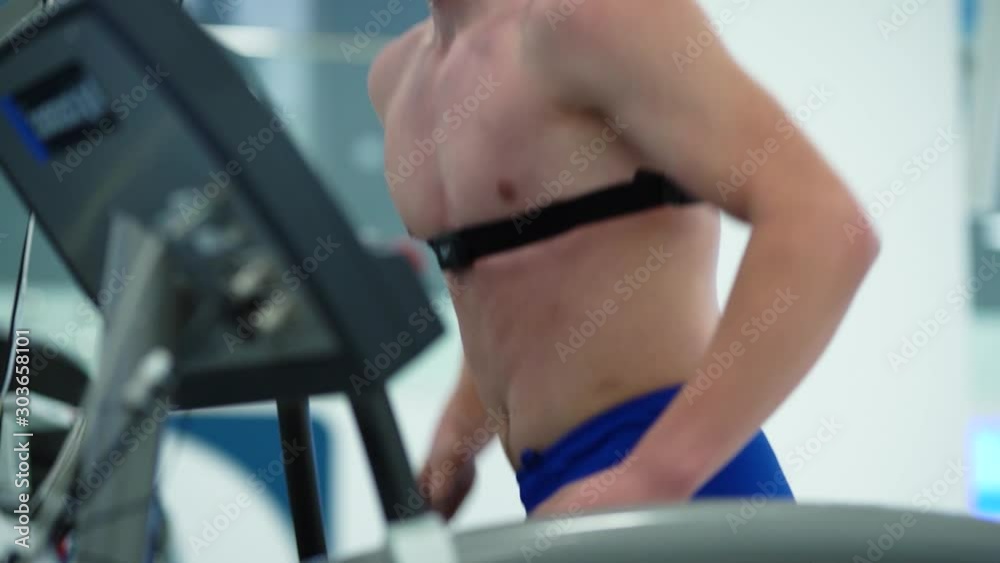 Man athlete going trough the testing on treadmill in modern sport science lab. triathlete workout testing endurance preparing to the race. Professional sport analyzing in action Man athlete going trough the testing on treadmill in modern sport science lab. triathlete workout testing endurance preparing to the race. Professional sport analyzing in action