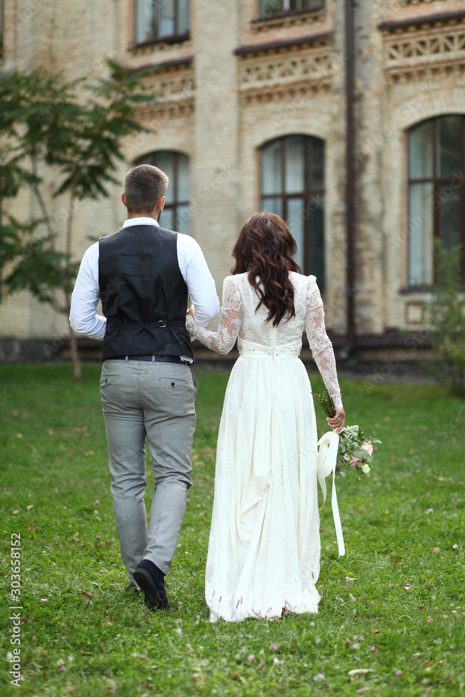 bride and groom walking in park