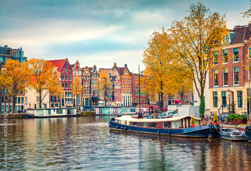 Splendid autumn scene of Amsterdam city. Famous Dutch channels and great cityscape. Colorful morning landscape in Netherlands, Europe. Traveling concept background..