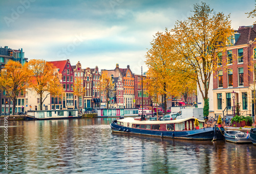 Splendid autumn scene of Amsterdam city. Famous Dutch channels and great cityscape. Colorful morning landscape in Netherlands, Europe. Traveling concept background..