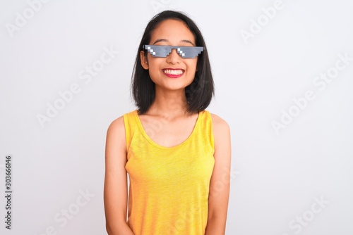 Young beautiful chinese woman wearing thug life sunglasses over isolated white background with a happy and cool smile on face. Lucky person.