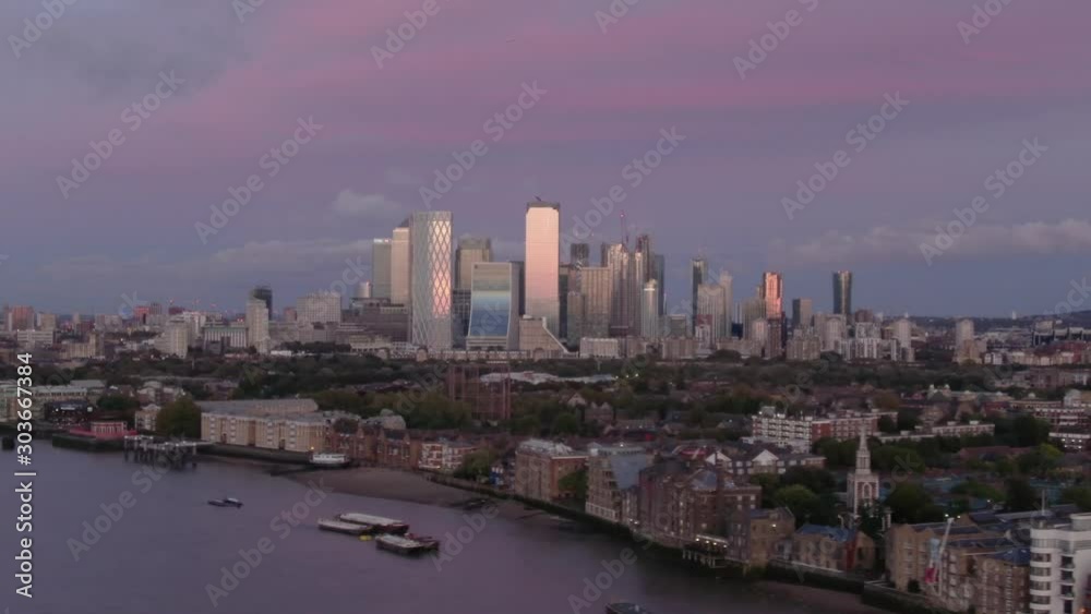 Aerial drone distant view of Canary Wharf Central Business District Towers of London's Docklands Isle of Dogs Canada Square Skyline at sunset Aerial drone distant view of Canary Wharf Central Business District Towers of London's Docklands Isle of Dogs Canada Square Skyline at sunset