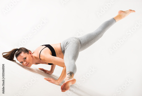 Slim woman doing advanced posture on a rug