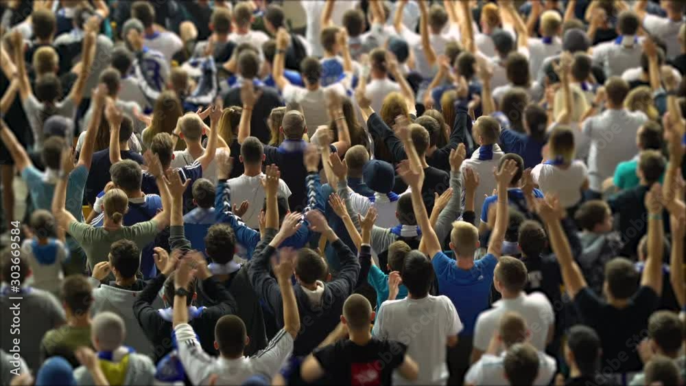 Crowd of football soccer fans cheering unanimously, mass control, united people. Sports fans cheering, enjoying the game