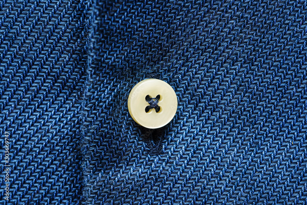Blue shirt fabric with button. Textile background Blue shirt fabric with button. Textile background
