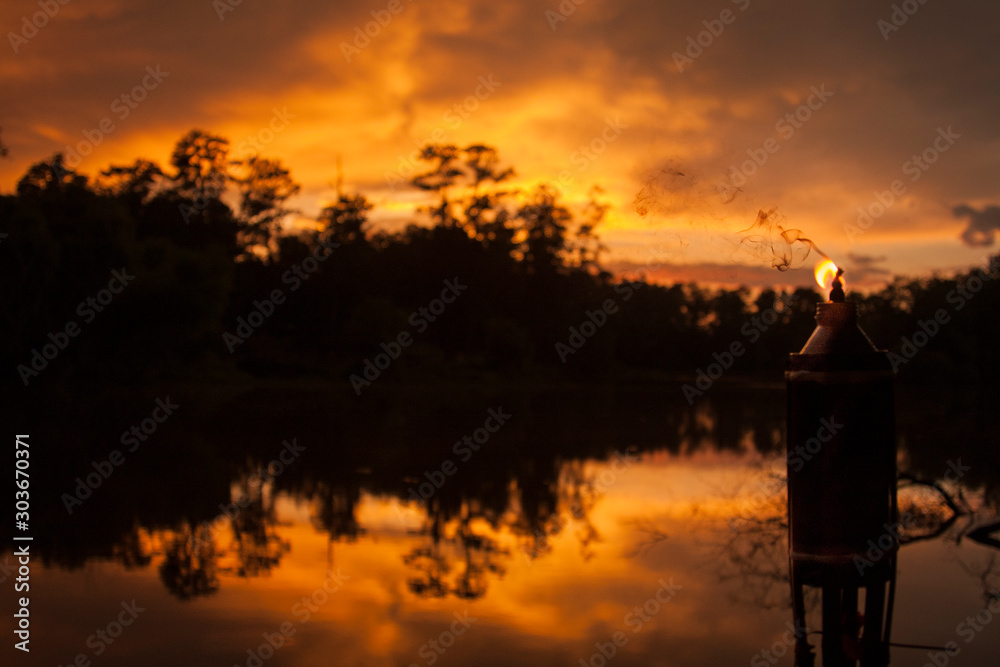 Lake sunset with tiki torch Lake sunset with tiki torch