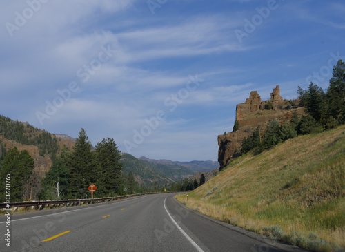 Beautiful view of a winding road with the Chimney Rock, an imposing rock formation along North Fork Highway to Yellowstone National Park.