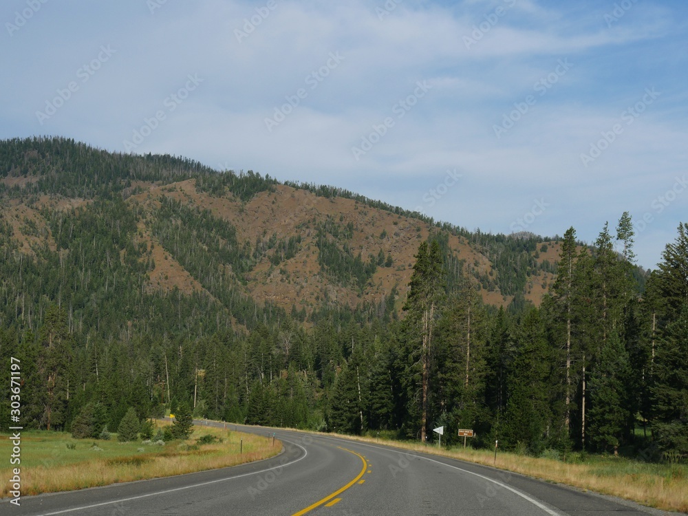 Upward winding road along North Fork Highway heading toward the east entrance of Yellowstone National Park.