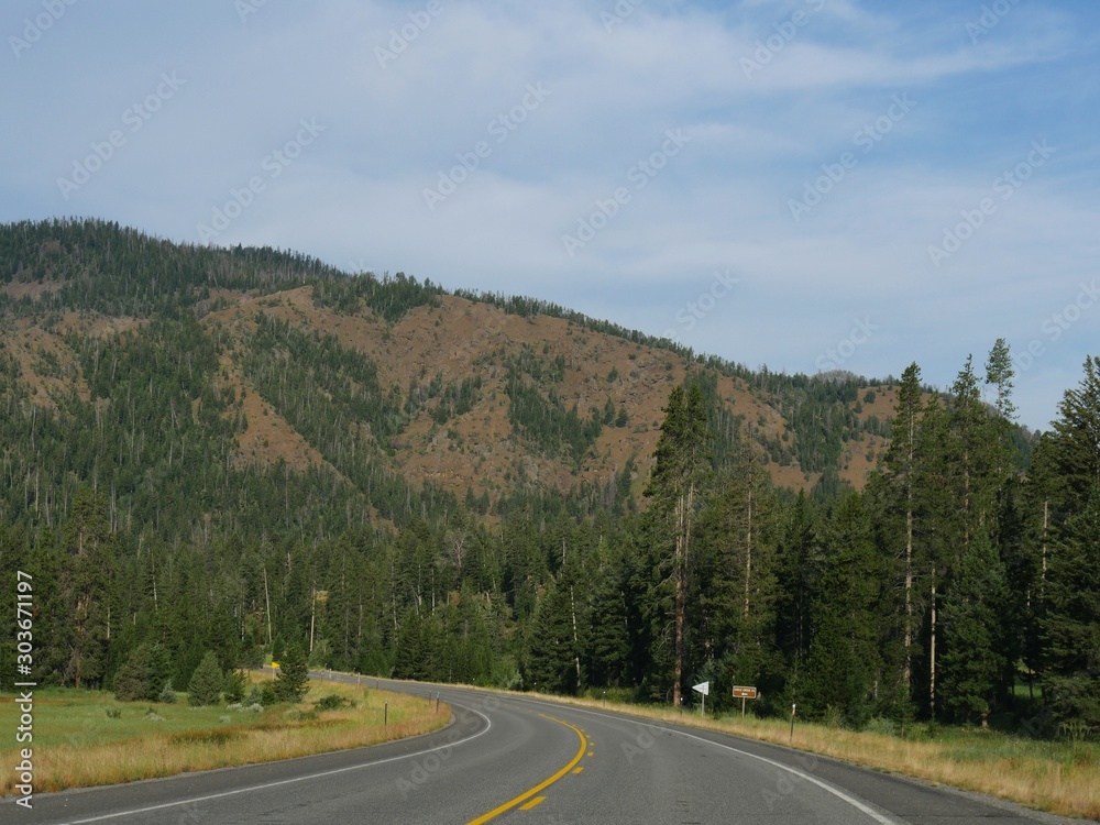 Upward winding road along North Fork Highway heading toward the east entrance of Yellowstone National Park. Upward winding road along North Fork Highway heading toward the east entrance of Yellowstone National Park.