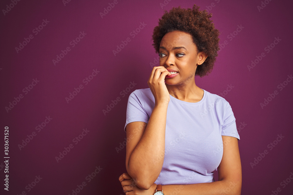 Young beautiful african american woman with afro hair over isolated purple background looking stressed and nervous with hands on mouth biting nails. Anxiety problem. Young beautiful african american woman with afro hair over isolated purple background looking stressed and nervous with hands on mouth biting nails. Anxiety problem.