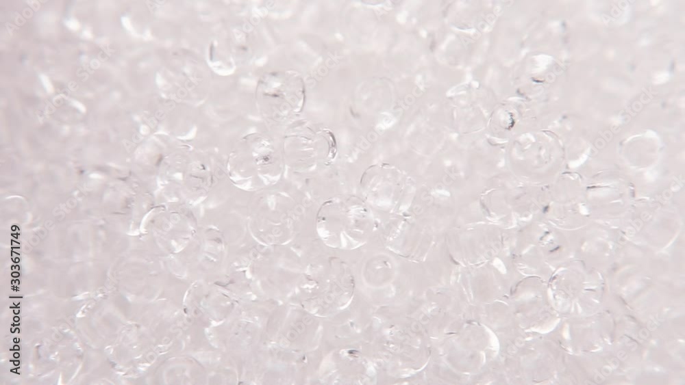 Pouring white clear beads into a white plate. Pouring white clear beads into a white plate.